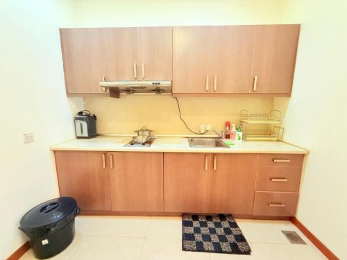 a small kitchen with wooden cabinets and a sink at Park View Service Apartment By Kualalampur in Kuala Lumpur