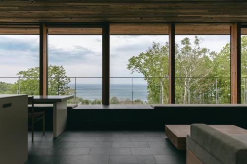 a room with large windows and a view of the ocean at 山郷 Villas in Nature in Otaru