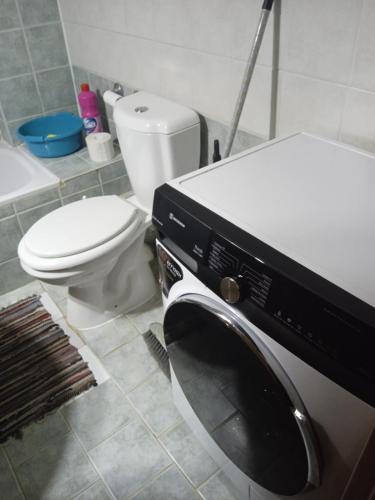 a bathroom with a toilet and a washing machine at MyseA Lovelight Kalyves in Kalyves Poligirou