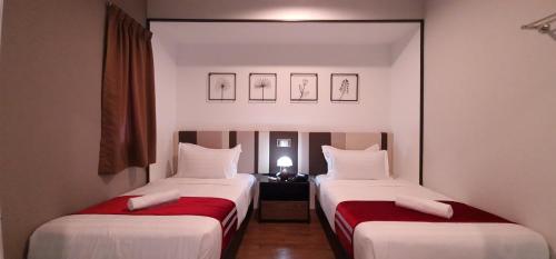 two beds in a hotel room with red sheets at Maritime Suite by Ocean Luxe 2BR Seaview Dryer Water Dispenser in George Town