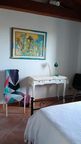 a bedroom with a white desk and a chair at Buena Vista in SantʼAntìoco