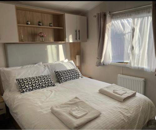a bedroom with a bed with two towels on it at Willerby lamberhurst in Westgate-on-Sea