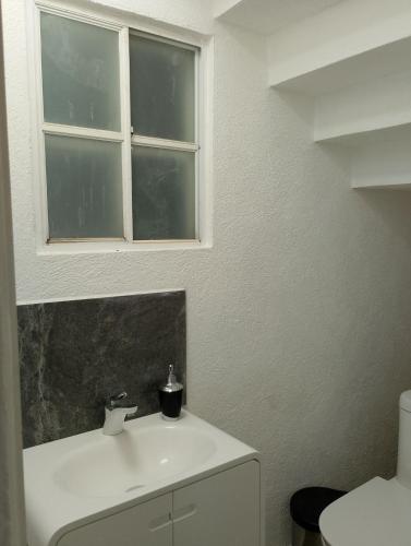 a bathroom with a white sink and a window at Playa, amplitud y tranquilidad in Acapulco