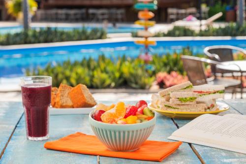 a table with a bowl of fruit and a drink at Salinas Maragogi All Inclusive Resort in Maragogi