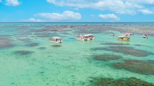 a group of boats in the water in the ocean at Salinas Maragogi All Inclusive Resort in Maragogi