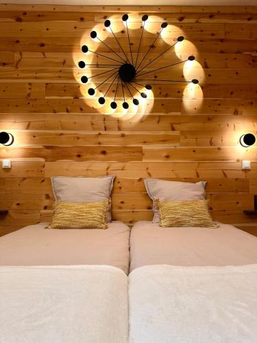 - une chambre avec 2 lits et une horloge murale dans l'établissement Auberge Le Glacier Bleu, à Mont-Dauphin