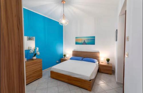 a bedroom with a bed and a blue wall at Port Island - Second Floor in Isola delle Femmine