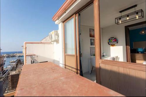 a balcony with a table and a view of the ocean at Port Island - Second Floor in Isola delle Femmine