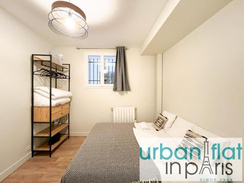 une petite chambre avec un lit et une fenêtre dans l'établissement Urban Flat 07 - Opera Grands Boulevards Flat, à Paris