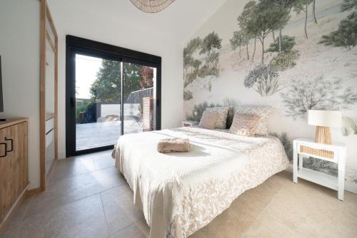 une chambre avec un lit et une grande fenêtre dans l'établissement Maison LaCanPon, 3 maisons réunies en bord de canal à Cazaux, à La Teste-de-Buch