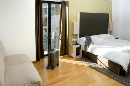 a hotel room with a bed and a suitcase at Hospedium Hotel Convento de Santa Ana in Atienza