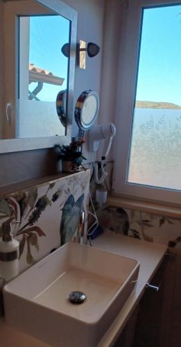 a bathroom with a sink and a mirror at Buena Vista in SantʼAntìoco