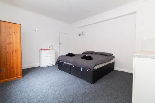 a bedroom with a bed and a dresser at Pebbles Guest House Room 1 in Southampton
