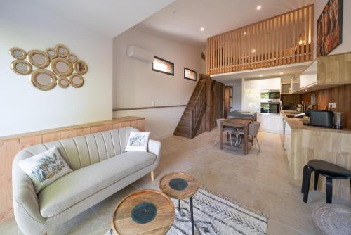 un salon avec un canapé et une cuisine dans l'établissement Maison LaCanPon, 3 maisons réunies en bord de canal à Cazaux, à La Teste-de-Buch