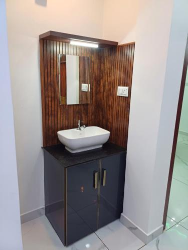 a bathroom with a sink and a mirror at VR Homes in Ernakulam