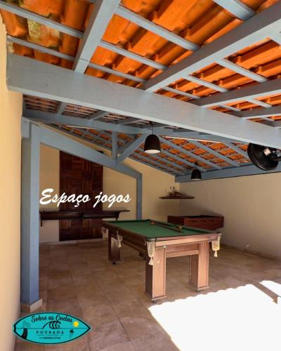 a room with a ping pong table and a ceiling at Pousada Sobre as Ondas in Saquarema
