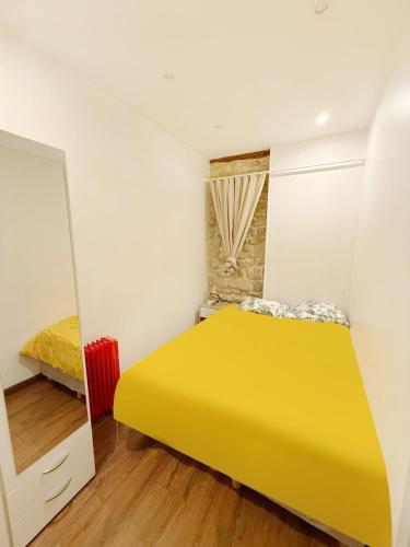 - une chambre avec un lit jaune et un miroir dans l'établissement Appartement 1 Salon et 1 Chambre Proche Notre Dame Paris 5 Centre Paris, à Paris