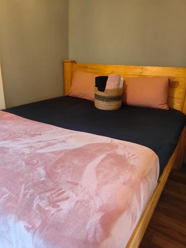 a bed with a basket sitting on top of it at The Cozy Cabin in Pretoria