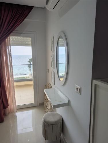 a white bathroom with a sink and a mirror at Beachfront Dream, WaveHaus in Akouda