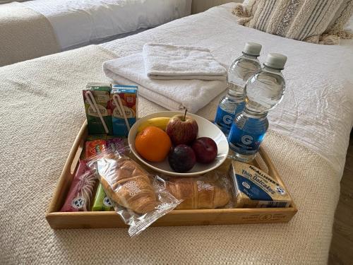 a tray with a bowl of fruit and bottles of water at Carnegie Lodgings, Tain in Tain