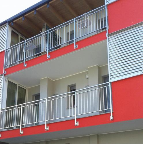 an apartment building with red and white balconies at La Casa Di Emma in Rozzano