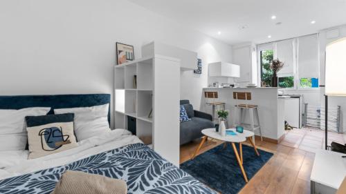 une chambre avec un lit et un salon dans l'établissement Le Bleu Roi, à Versailles