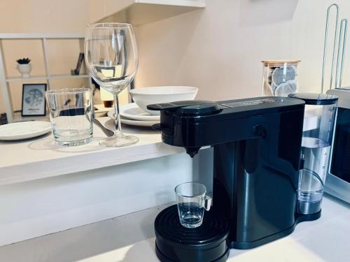 une cafetière noire assise sur un comptoir avec des verres dans l'établissement Le Bleu Roi, à Versailles