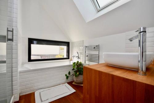 Un baño con lavabo y ventana. en Kerguille, villa avec piscine, en La Trinité-sur-Mer