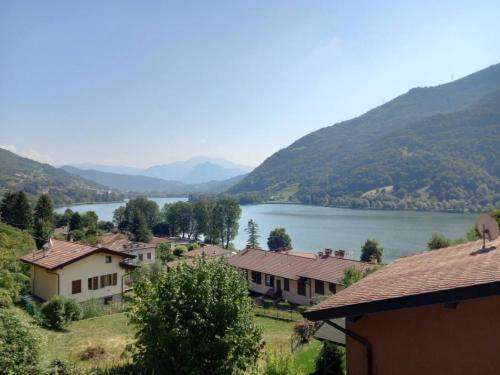 a view of a lake with houses and mountains at Lakefront Apartment with Panoramic Pool in Ranzanico