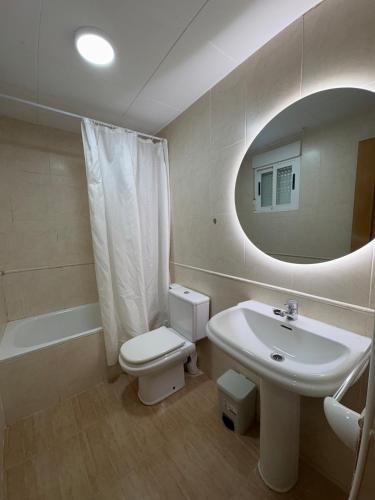 a bathroom with a sink and a toilet and a mirror at Alpen 1 Voramar Playa Norte in Peniscola
