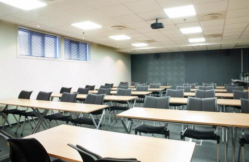 an empty lecture room with tables and chairs at Best Western Tingvold Park Hotel in Steinkjer