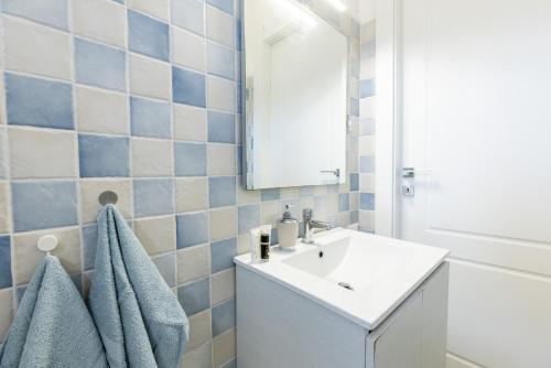a bathroom with a white sink and a mirror at Superb Loft Baja Sardinia -Panoramic Sea View- in Baja Sardinia