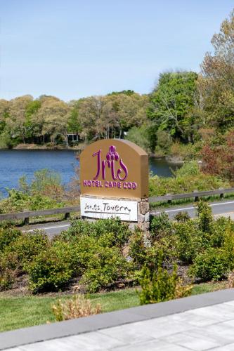 a sign for a hotel care company in front of a river at Hotel Cape Cod in Falmouth