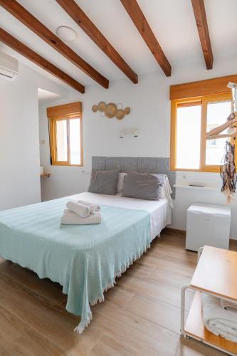 a bedroom with a large bed in a room with wooden ceilings at Iaia Carmen in Tabarca
