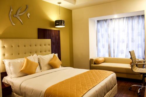 a bedroom with a bed and a couch and a window at Hotel Southern Comfort in Chennai