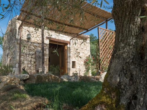 a stone building with a tree in front of it at Agriturismo Fontenuova in Saturnia