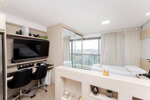 a hotel room with a television and a bed at 7th Avenue - Centro | Curitiba | Gonzaga Stays in Curitiba