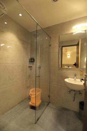 a bathroom with a shower and a toilet and a sink at Mumbai House Express Udaipur in Udaipur