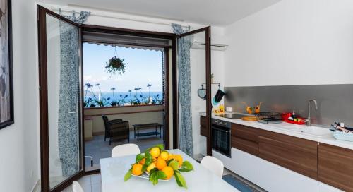 een keuken met een tafel met daarop een schaal fruit bij Alba apartment in Taormina