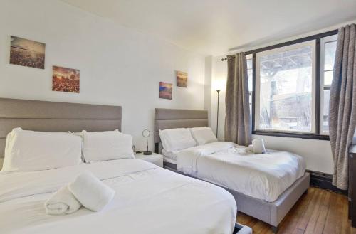 西纽约3BR Skyline Apt in Bustling District I Great Value NJ5的有两张床和一扇窗户的卧室