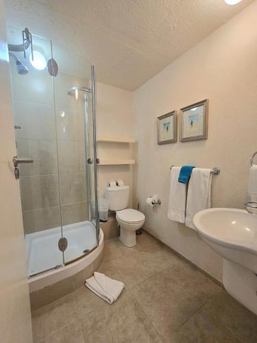 un bagno con doccia, WC e lavandino di 5 St Lawrence Beach Condo a Christ Church