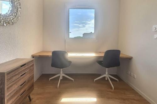 2 chaises assises à côté d'un bureau et d'une fenêtre dans l'établissement Appartement spacieux pour 4 personnes à 500m de la me, à Sérignan