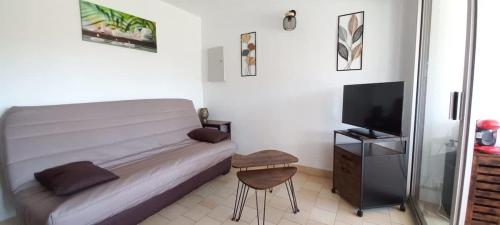 - une chambre avec un lit, une télévision et un tabouret dans l'établissement Agréable appartement avec piscine, à Valras-Plage