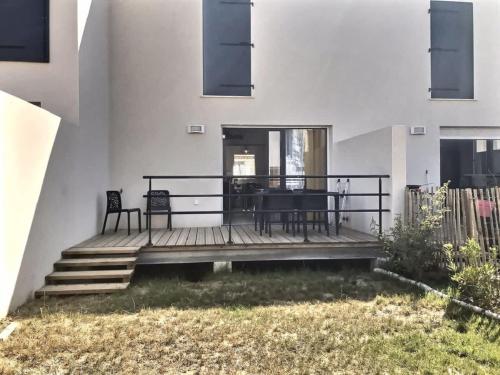 une maison avec une terrasse avec une table et des chaises dans l'établissement Villa moderne avec 2 chambres dans une résidence à 500m de la plage, à Sérignan