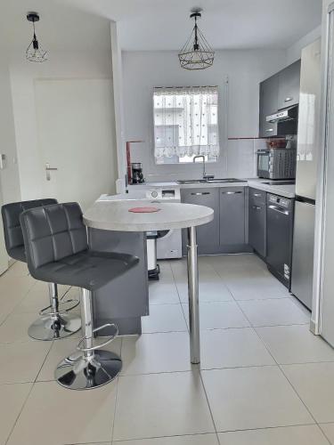 - une cuisine avec une table et deux chaises dans l'établissement Villa moderne avec 2 chambres dans une résidence à 500m de la plage, à Sérignan