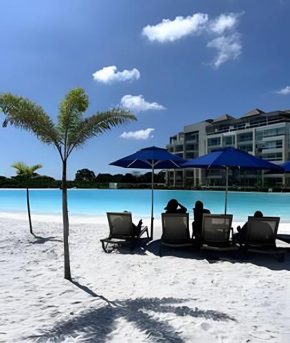 a beach with chairs and umbrellas on the sand at Vista impresionante y cama king en Baia Kristal in Los Arrayanes