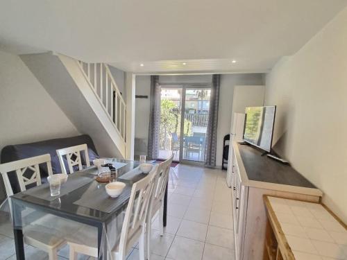 une salle à manger avec une table et quelques chaises dans l'établissement Petit pavillon pour 6 personnes dans une résidence avec piscine, à Valras-Plage
