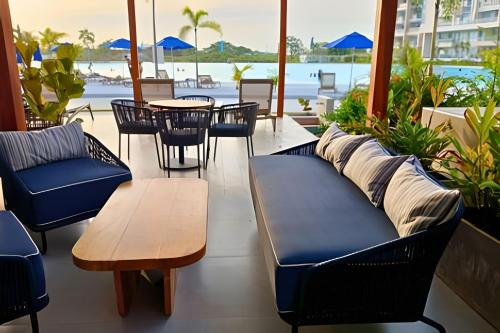 a patio with a couch and chairs and a table at Vista impresionante y cama king en Baia Kristal in Los Arrayanes