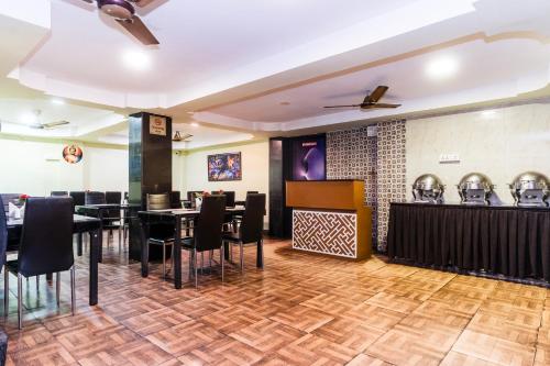 a restaurant with tables and chairs and a bar at Apples Balaji Inn in Siliguri