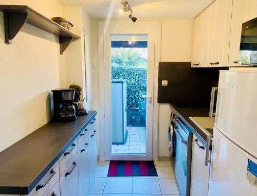 une cuisine avec une porte menant à une terrasse dans l'établissement Petit pavillon pour 6 personnes dans une résidence avec piscine, à Valras-Plage